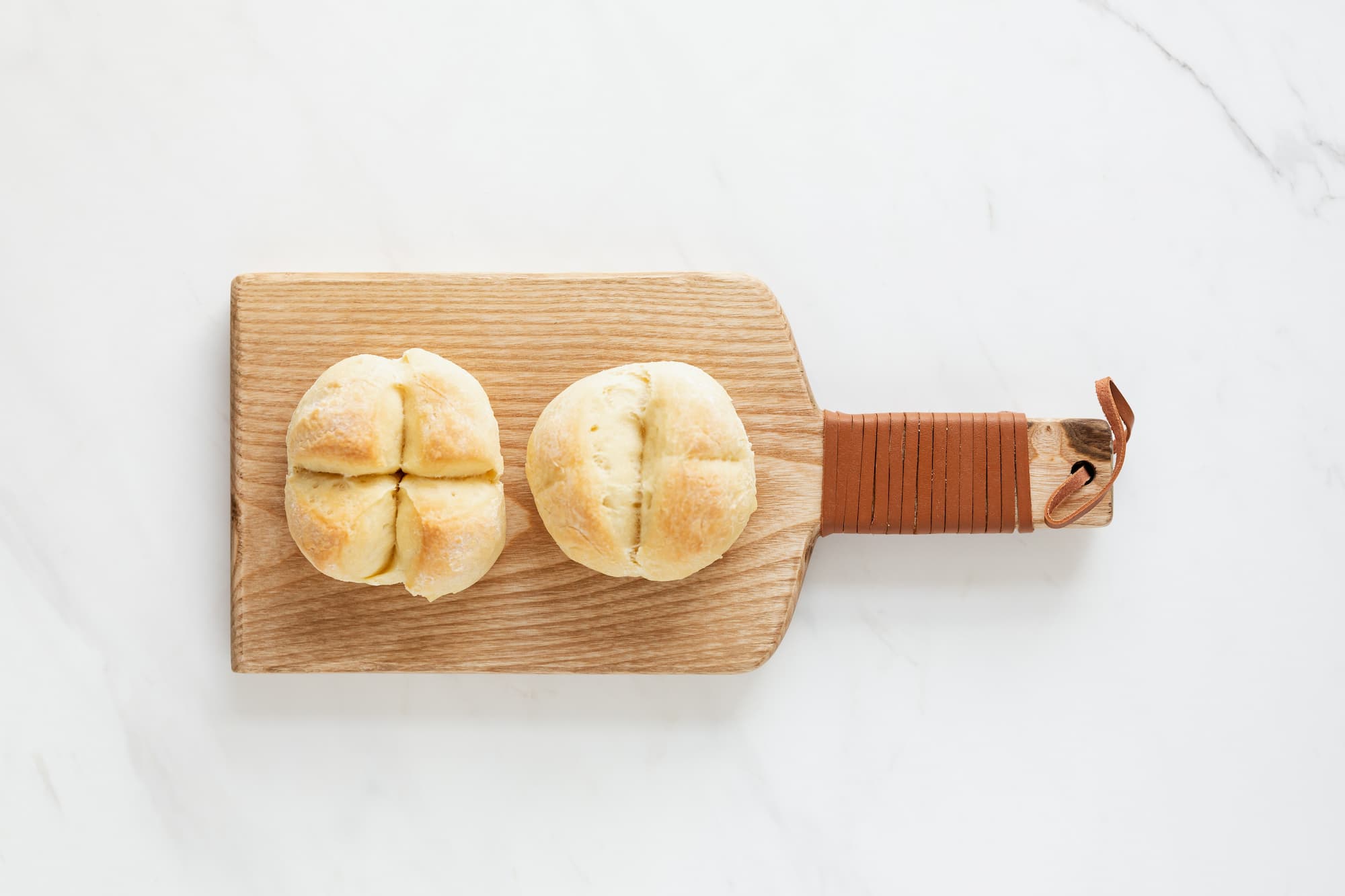 Two bread rolls on a cutting board
